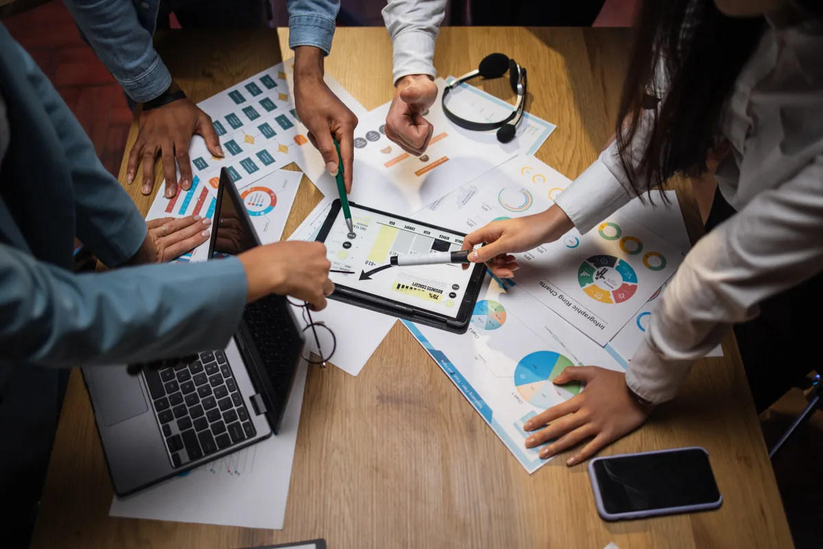 Analytics KPI tracking setup with multi-ethnic brokers analyzing financial statistics